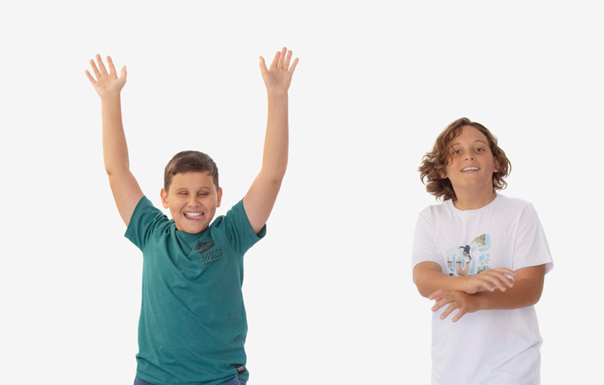 Image of 2 happy looking boys. One has his arms raised in the air in celebration. The other looks happy with his arms crossed.